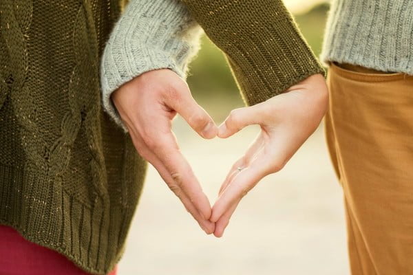 Pareja que une sus manos formando un corazón. Imagen romántica, pareja que se quiere