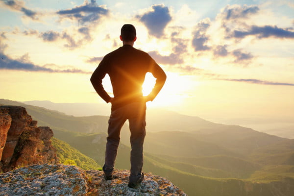 Adulto en la naturaleza, de espaldas mirando una puesta de sol. Da sensación de calma, la que buscan las personas que acuden al psicólogo para adultos